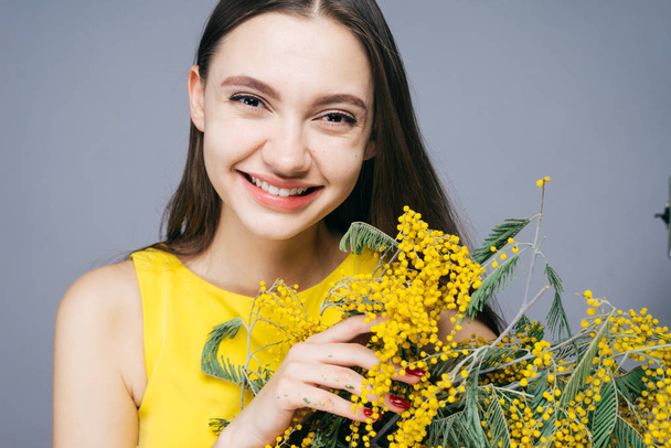 beautiful happy woman holding yellow flowers in hands - Zdjęcie, obraz