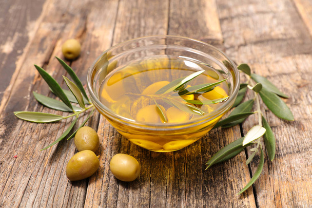 olive oil in glass bowl with olives and olive branches - Foto, Imagem