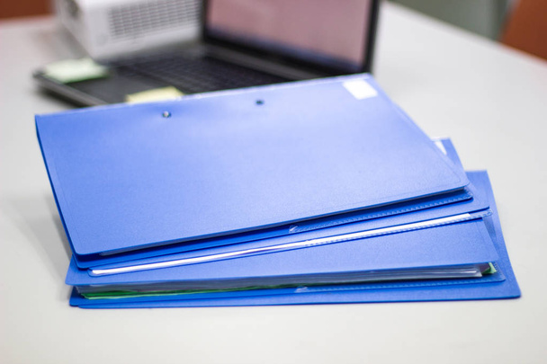 cartella di file con documenti e sfondo notebook sul tavolo bianco, concetto di business
. - Foto, immagini