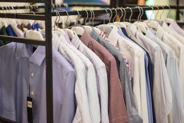 Viele Männerkleider auf Kleiderbügeln im Supermarkt   - Foto, Bild