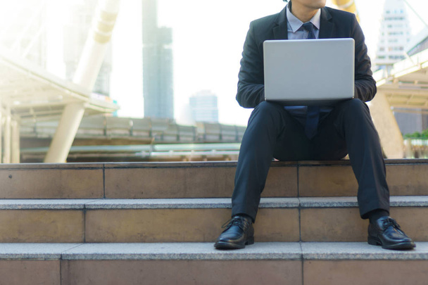 Businessman sitting on the footsteps with laptop  - Zdjęcie, obraz