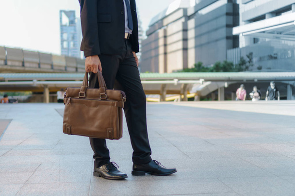 Üzletember, séta a városban, és a gazdaság táska - Fotó, kép