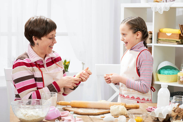 Mère et fille cuisinent à la maison, faisant la pâte pour les petits pains
 - Photo, image