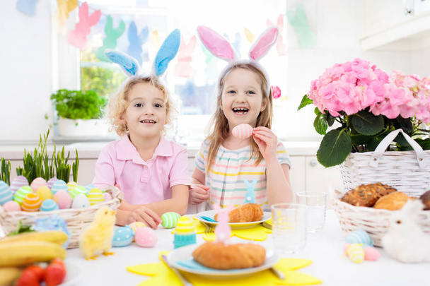 Caza de huevos de Pascua. Niños con orejas de conejo y cesta
. - Foto, imagen