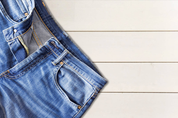 Close up of jeans pants on wooden background - Foto, afbeelding