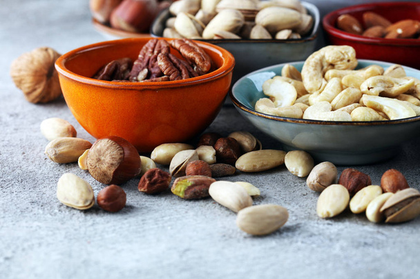 mixed nuts on grey background. Healthy food and snack. Walnut, p - Photo, Image