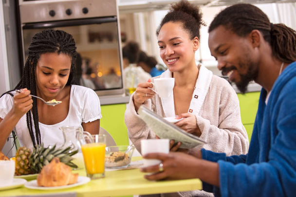 Afro American girl with patents having breakfast on morning - Foto, afbeelding