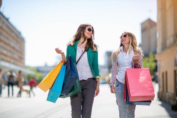 Beautiful girls with shopping bags walking at the mall - Foto, Imagen