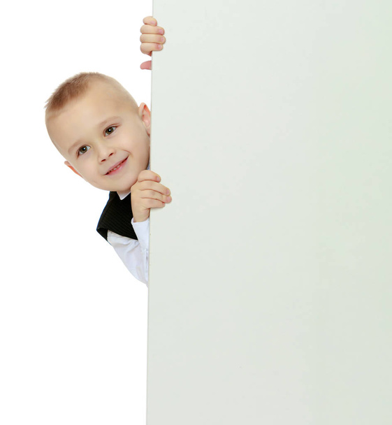 boy peeks out from behind the banner - Fotoğraf, Görsel