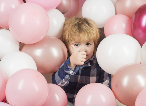 Хлопчик на вечірці показує великі пальці вгору. Красива дитина серед рожевих кульок задоволена подарунками та щасливим дитинством. Діти крупним планом. Прикраса біло-рожевих кульок на заході. Відкриття магазину дитячих іграшок
 - Фото, зображення