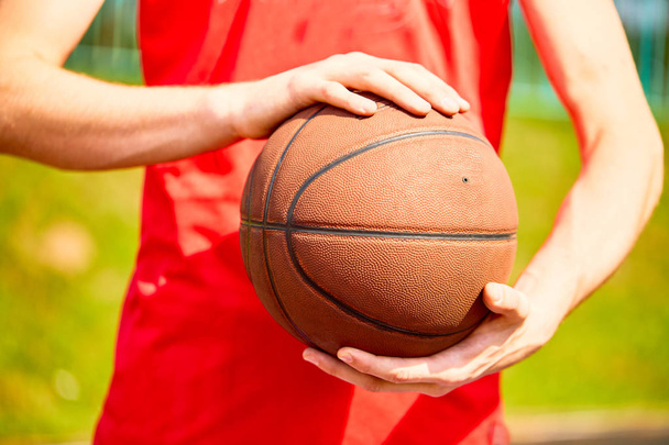 man holding basketball ball, close-up  - 写真・画像