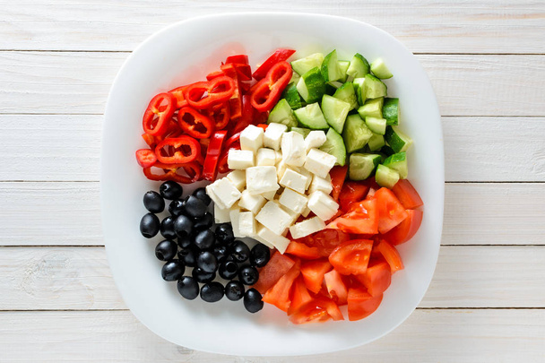 Fresh vegetables and cheese in a plate on a wooden table. Healthy food - Φωτογραφία, εικόνα