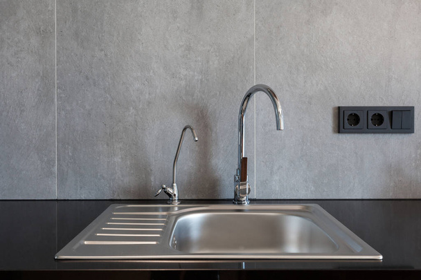 Detail of a rectangular designer kitchen sink with chrome water tap - Foto, Imagen