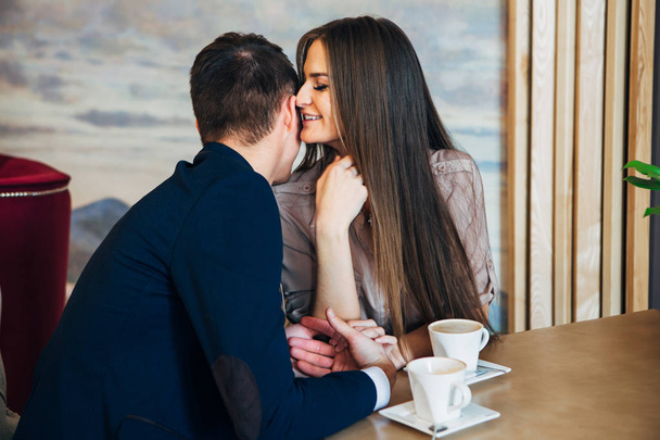 Dating in the cafe. Beautiful young couple sitting in the cafe, drinking coffee Love, dating - Photo, Image