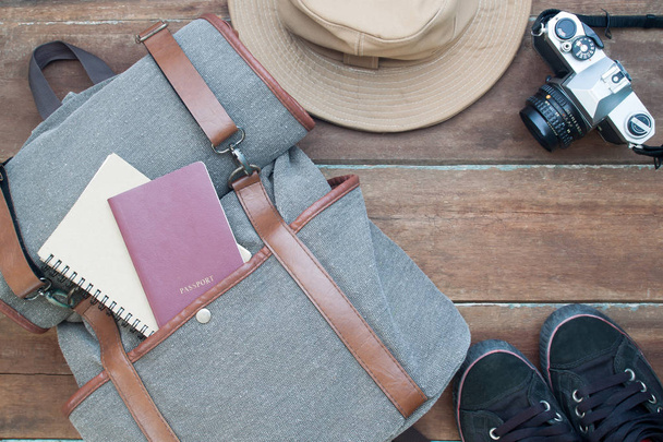Travel and journey concept, Man's items with passport, notebook and camera on wooden background - Фото, изображение