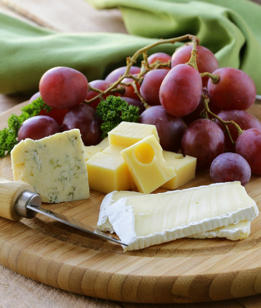 Käseplatte mit drei Käsesorten und Trauben - Foto, Bild