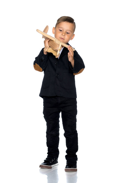 Little boy playing with wooden plane - Foto, imagen