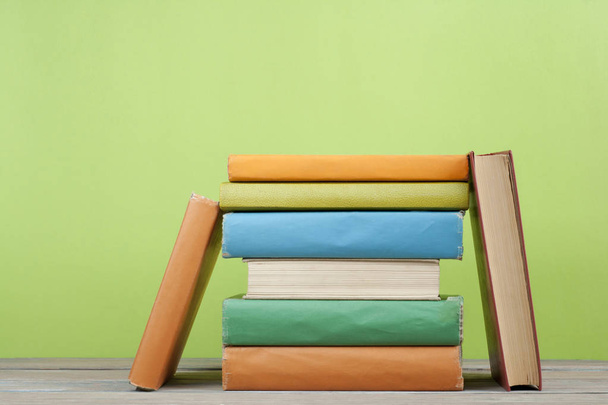 Stack of colorful books on the wooden table. Education background. Back to school. Copy space for text. - Photo, image