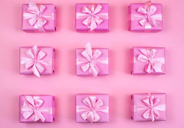 dekorative Weihnachtsgeschenkboxen mit rosa Farbe auf rosa Hintergrund. flache Ansicht von oben - Foto, Bild