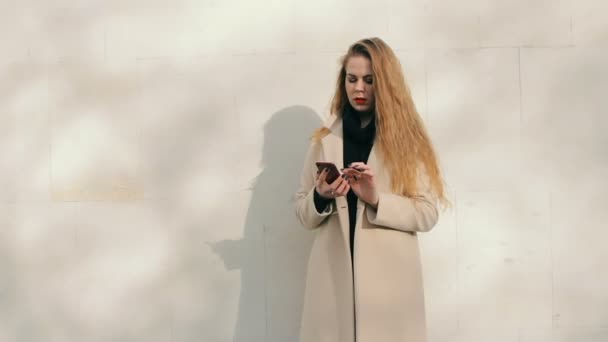 Woman looking like Nicole Kidman with phone buying online outdoors - Кадры, видео