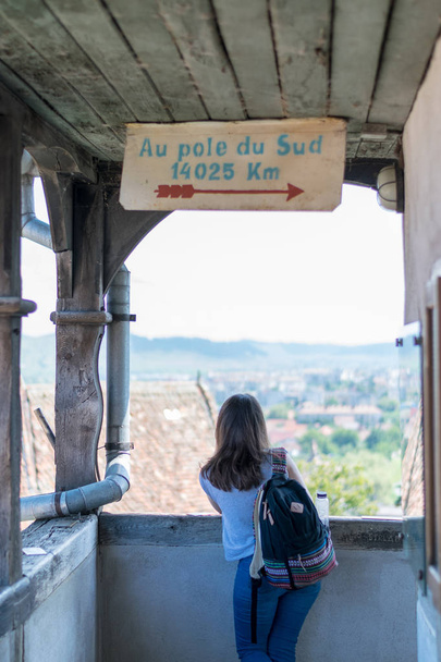 ein Mädchen, das an einem sonnigen Tag die Aussicht vom Glockenturm von Sighisoara bewundert. - Foto, Bild