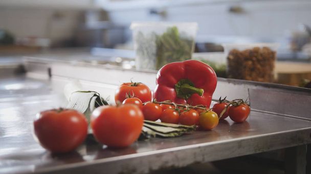 Овочі, помідори, паприка, цибуля-порей лежать на столі на комерційній кухні
 - Фото, зображення
