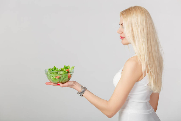 woman in white dress with fresh salad - Фото, зображення