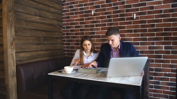 Twee jonge ondernemers werken op de Laptop In de coffeeshop - Video