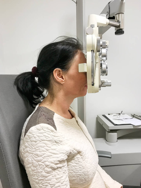Frau lässt ihr Sehvermögen beim Augenarzt testen - Foto, Bild