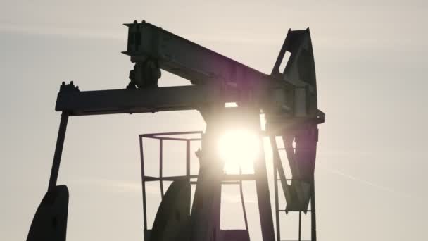 Крупный план работающего нефтяного насоса на фоне солнца
 - Кадры, видео