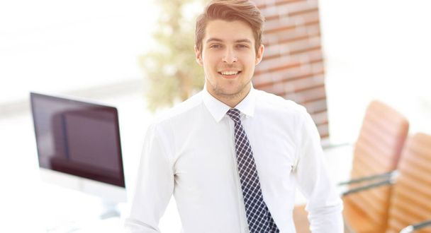 confident young businessman on background of office - Φωτογραφία, εικόνα
