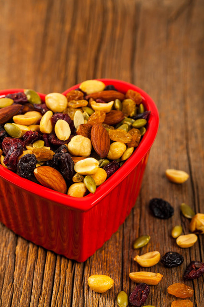 Energy Blend Trail Mix with Nuts and Dried Fruits in Heart Shaped Bowl. Selective focus. - Photo, Image
