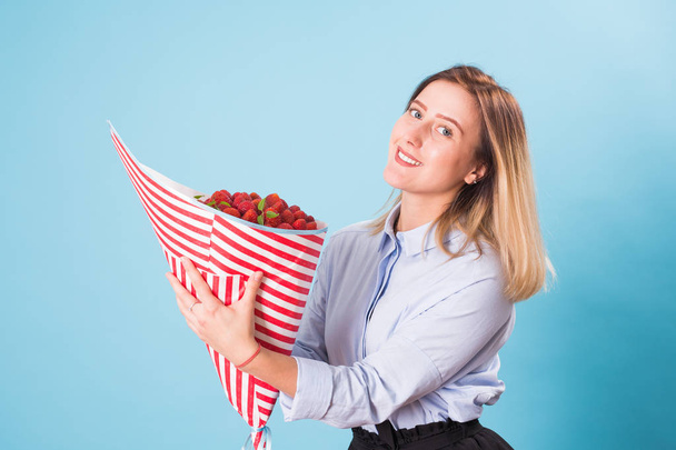Beautiful woman holding bouquet made of strawberry - Photo, Image