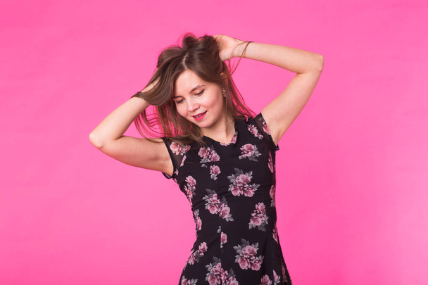 Fiatal nő egy ruha, egy rózsaszín háttér - Fotó, kép
