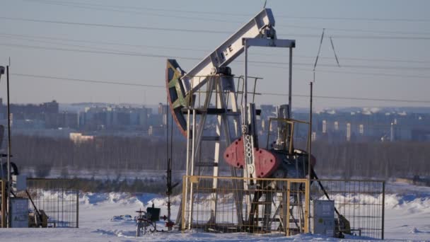 Рабочий насос для добычи нефти на фоне города
 - Кадры, видео