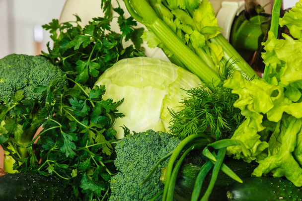Many green vegetables on kitchen table - Foto, immagini