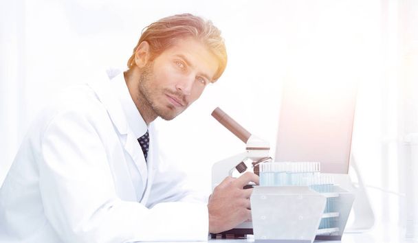 Male Chemist Scientific Reseacher using Microscope in Laboratory - Фото, изображение