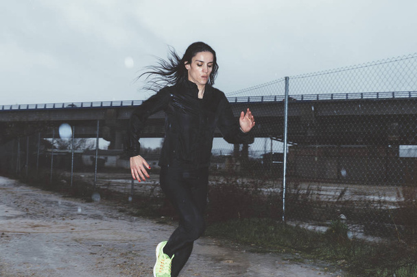 Woman doing sport in the open air, on rainy day - Photo, Image