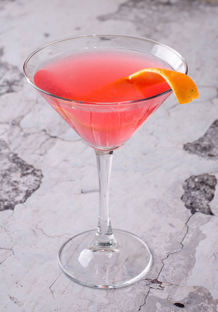 Вид зверху червоний апельсиновий коктейль Маргарет свіжий у келиху мартіні на сірому фоні. Меню барного алкоголю, смачний чайний схід сонця довгий напій для вечірки
. - Фото, зображення