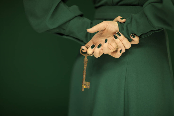 beautiful woman figure in dark green 50's dress holding vintage keys, hands with green nail polish - Fotoğraf, Görsel