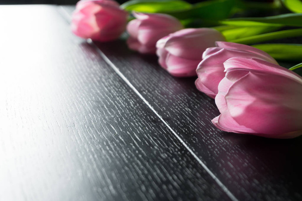 Граница с ярко-розовыми цветами тюльпанов на черном фоне
. - Фото, изображение