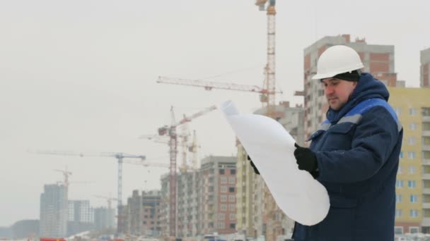Foreman with paper drawing plan at construction project - Footage, Video