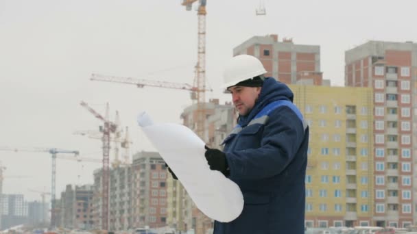 Foreman with paper drawing plan at construction project - Footage, Video