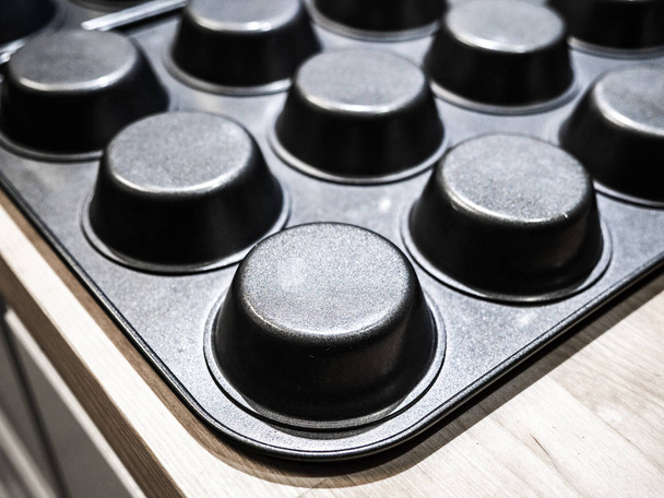 Closeup unsaturated photograph of gray metal cupcake baking pan with round circular shape great for a background image, wallpaper or backdrop. - Fotoğraf, Görsel