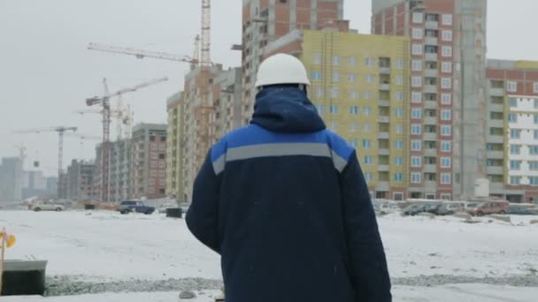 Foreman caminhando para os edifícios em construção
 - Filmagem, Vídeo