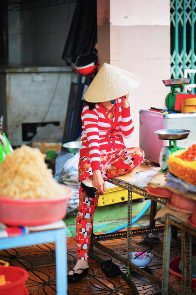 Woman in Vietnamese hat is talking mobile phone in Can Tho - Foto, afbeelding