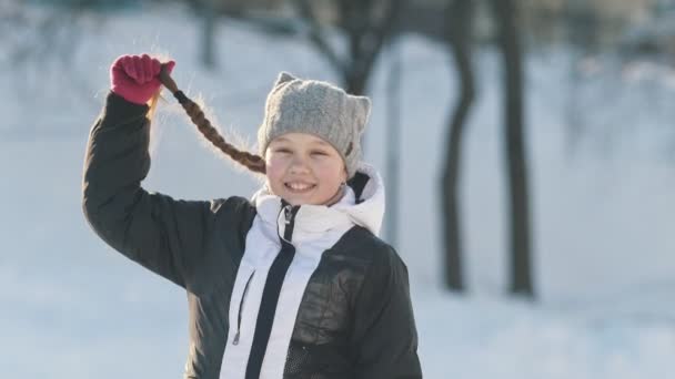 Portrét dospívající dívka s pigtailed nosit zimní oblečení v zimě venku - Záběry, video