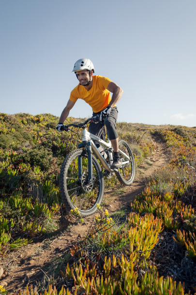 Гірський велосипедист їде по ґрунтовій стежці
 - Фото, зображення