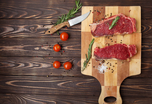 Raw steak with spices and ingredients for cooking. Top view - Фото, изображение