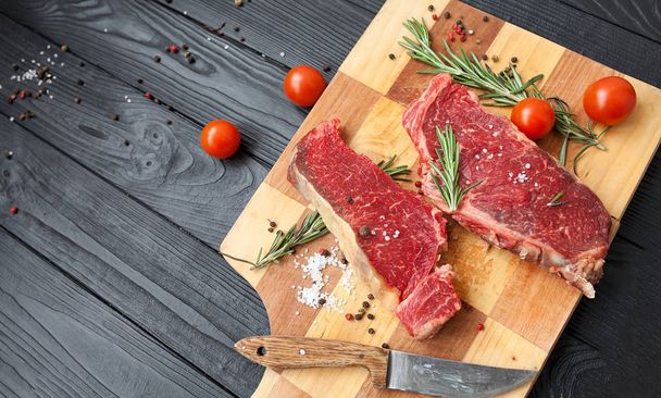 Raw ribeye beef steak cooking with ingredients. Top view with copy space - 写真・画像